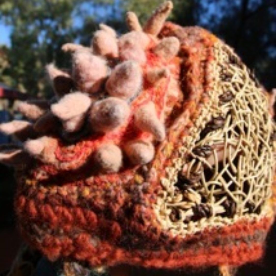 A close up of a knitted hat with spikes on it