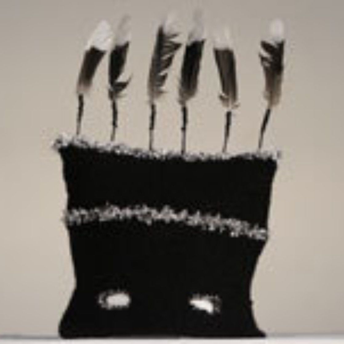 A black pillow with feathers on top of it