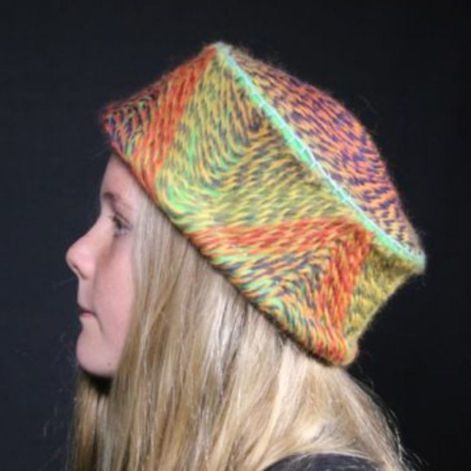 A woman is wearing a colorful hat on her head.