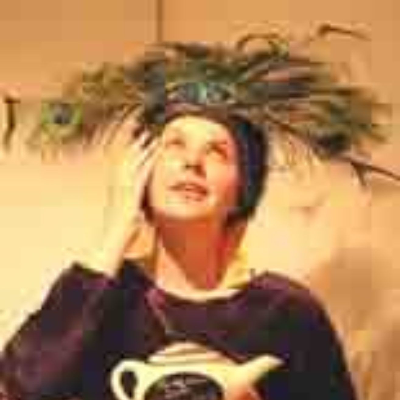 A woman wearing a peacock feather hat is holding a teapot.