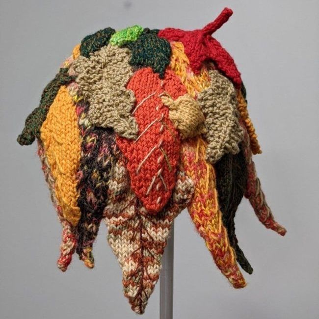 A colorful knitted hat with leaves on it