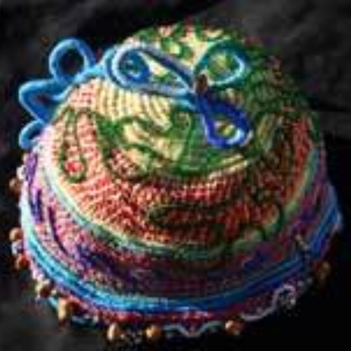 A colorful cake with a butterfly on top is sitting on a table.