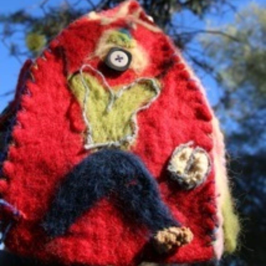 A red stuffed animal with a button on its head