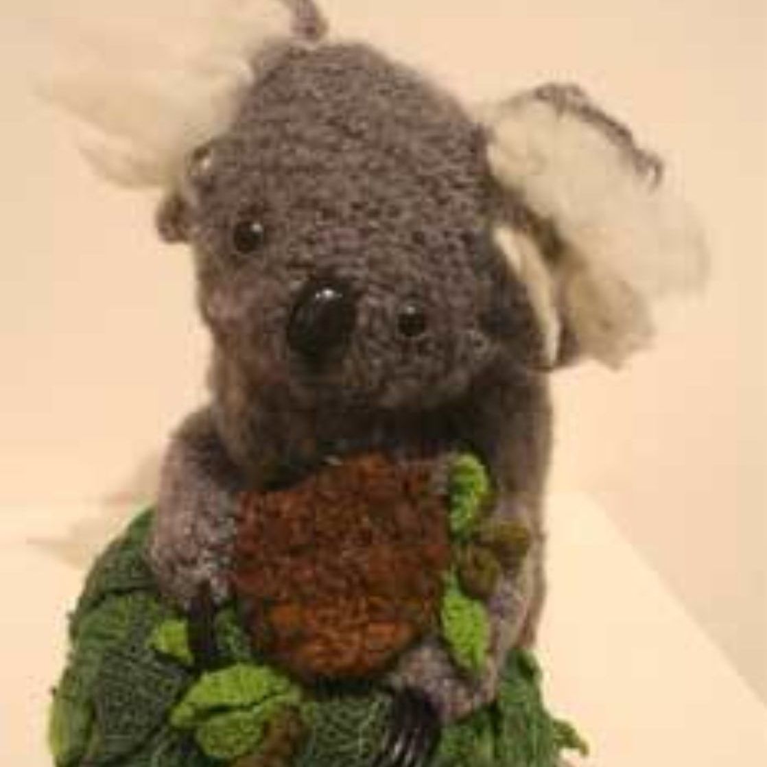 A stuffed koala bear is sitting on top of a pile of broccoli.