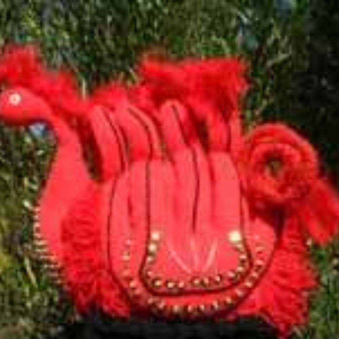 A red glove is sitting on top of a green grass covered field.