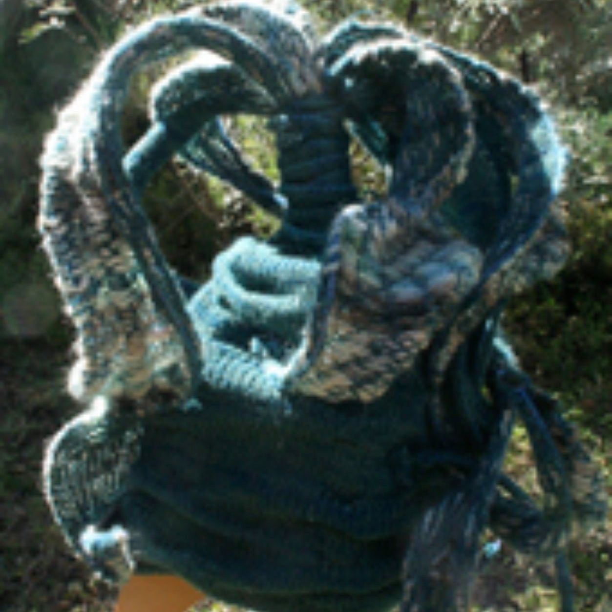 A person is holding a blue scarf in their hand.
