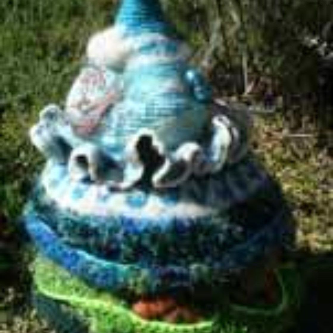 A crocheted hat is sitting on top of a pile of yarn.