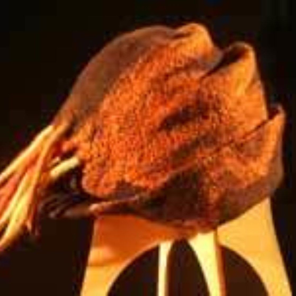 A close up of an orange hat on a wooden stand