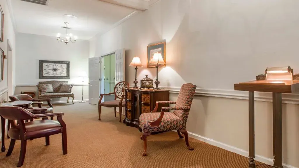 Long hallway with chairs, furniture, and wall decorations.