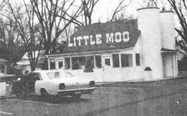 Little Moo restaurant with a car parked out front. Building has two silo-shaped towers.