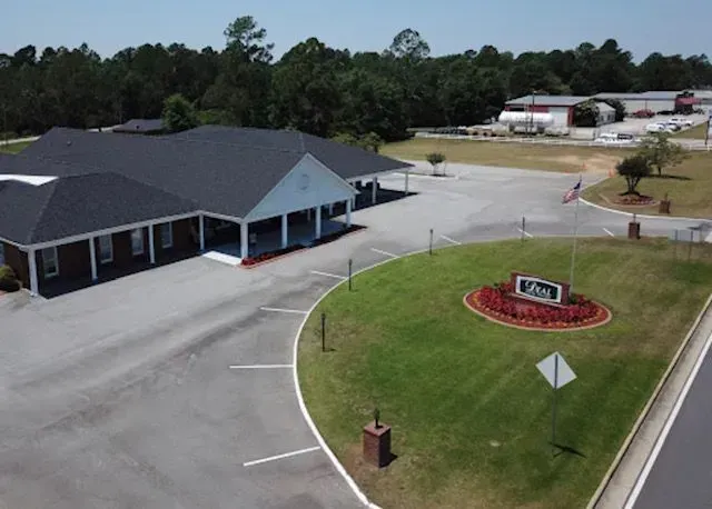 A brick building with a dark roof and a sign that reads 