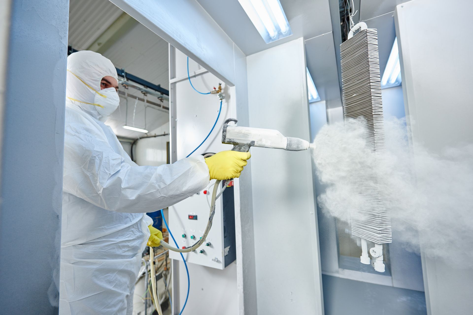 A man using industrial powder coating in Adelaide on metal for enhanced durability and finish