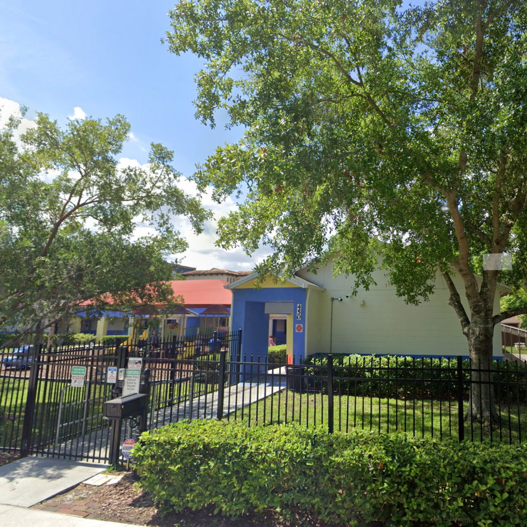 A white building with a blue door and a red roof