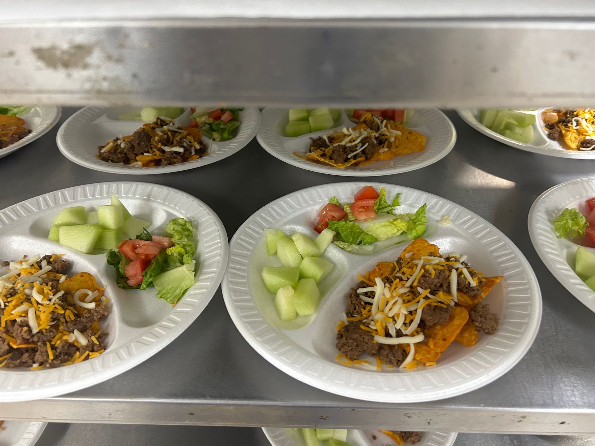 A bunch of plates of food are sitting on a shelf.