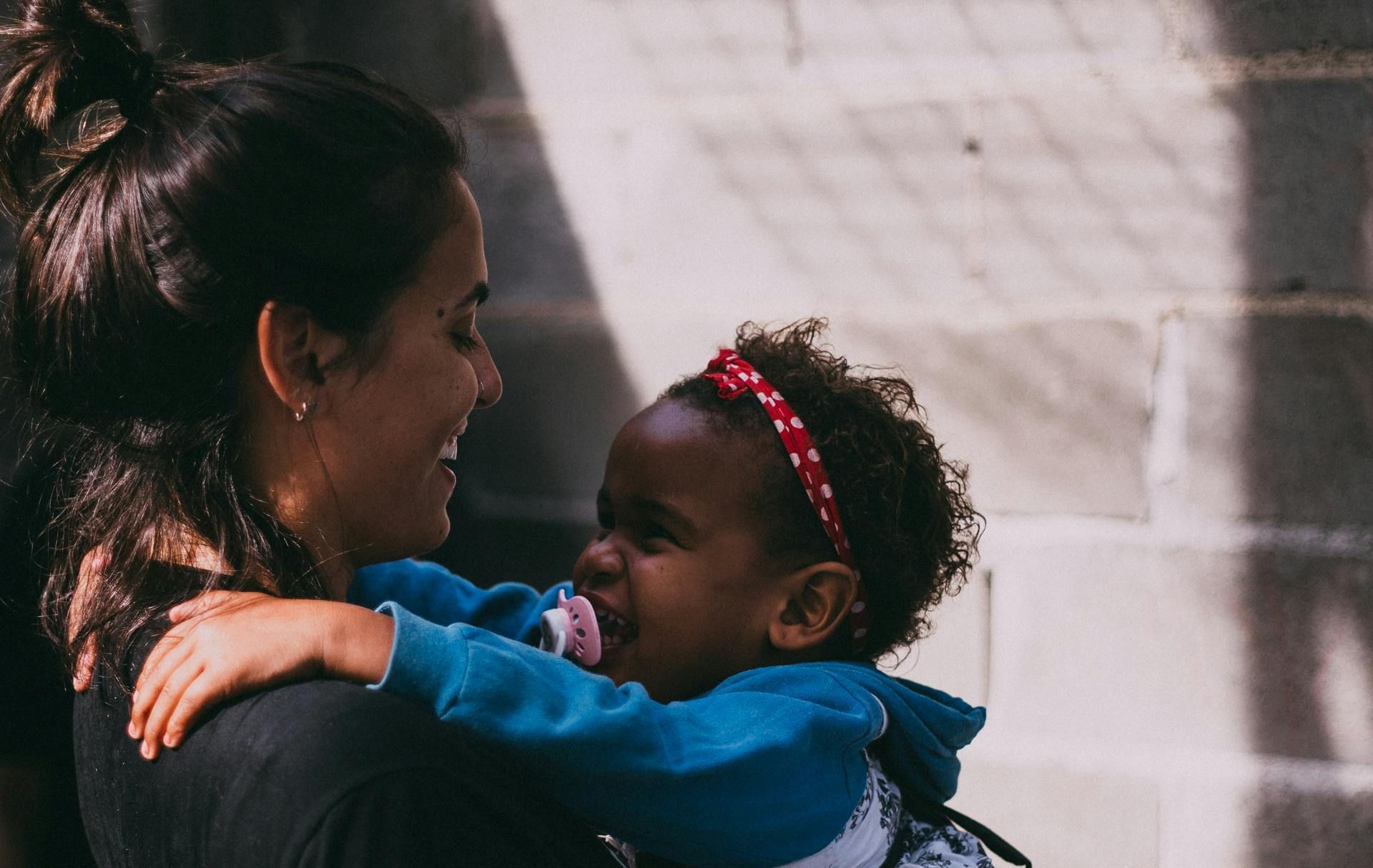 A woman is holding a baby in her arms.