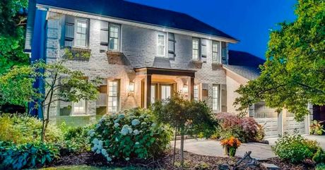 A large white house with a lot of windows is lit up at night.