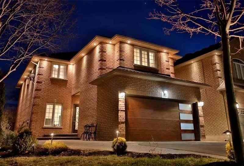 A large brick house is lit up at night