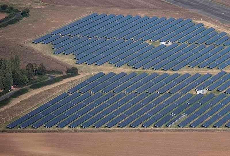 An aerial view of a large solar farm in a field.
