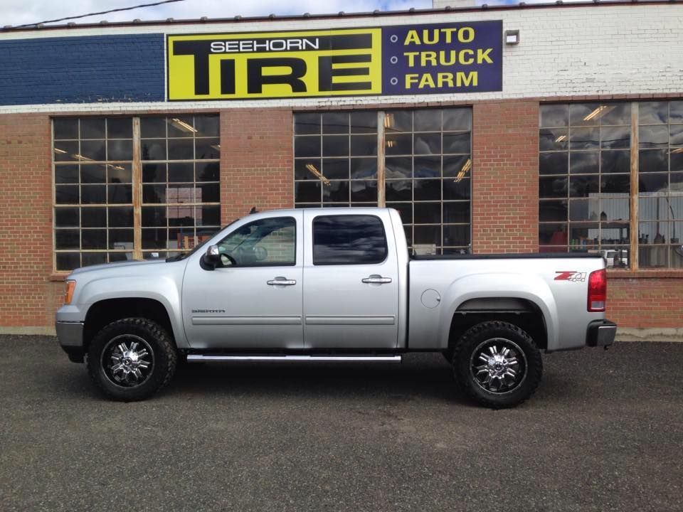 A silver truck is parked in front of a tire shop | Rockford Auto Inc