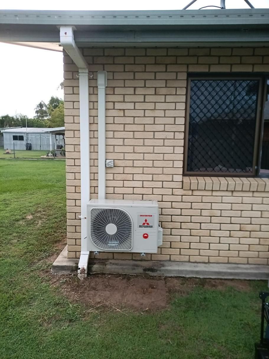 An Air Conditioner is Installed on the Side of a Brick — Instant Spark Electrical in Glen Isla, QLD