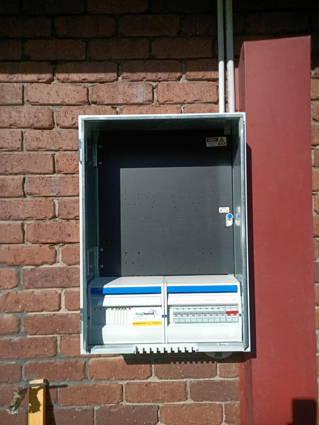 A Brick Wall With a Box Sitting on Top of It — Instant Spark Electrical in Glen Isla, QLD