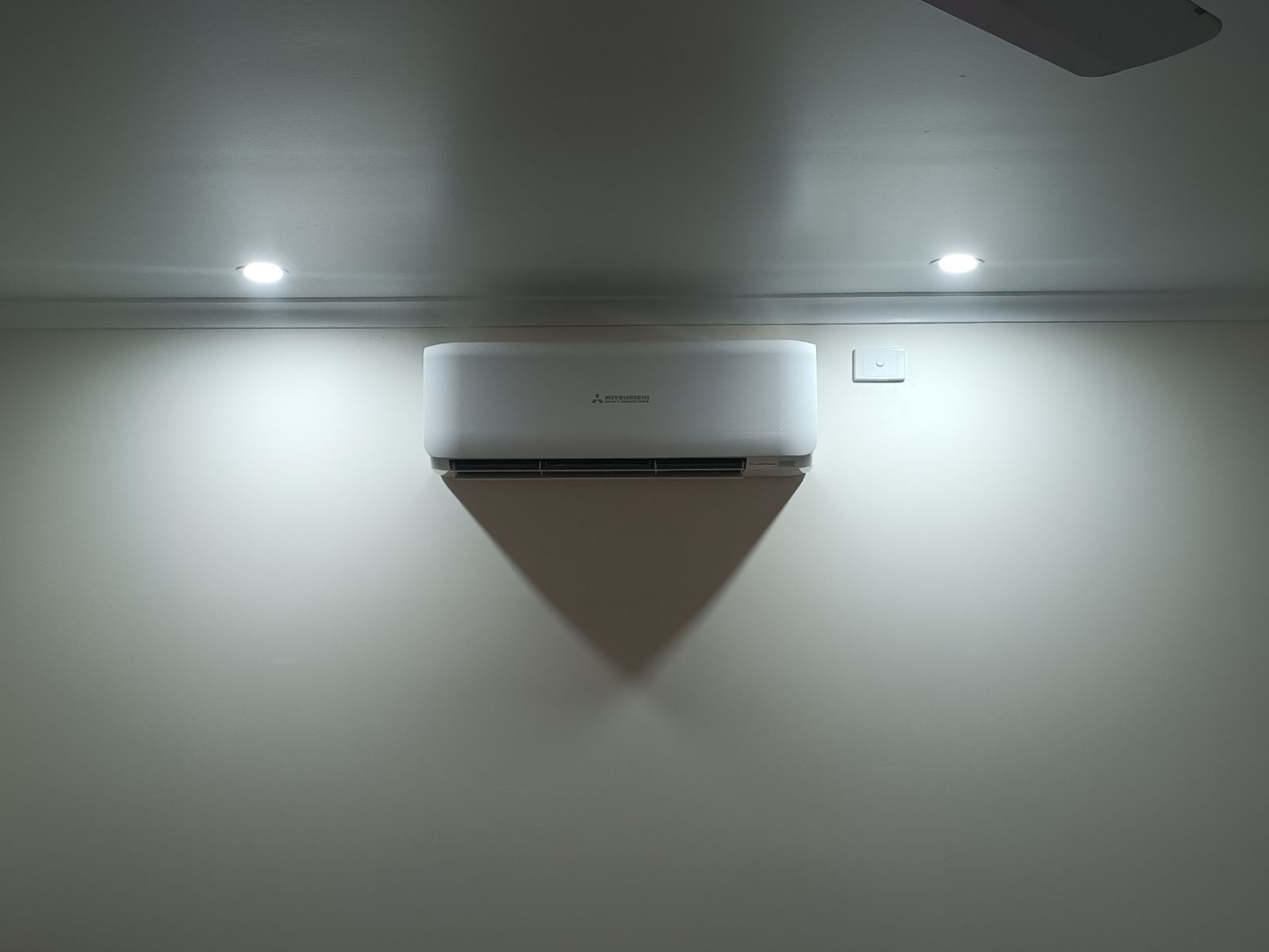 A Room With a Ceiling Fan and a Wall Mounted Air Conditioner — Instant Spark Electrical in Glen Isla, QLD