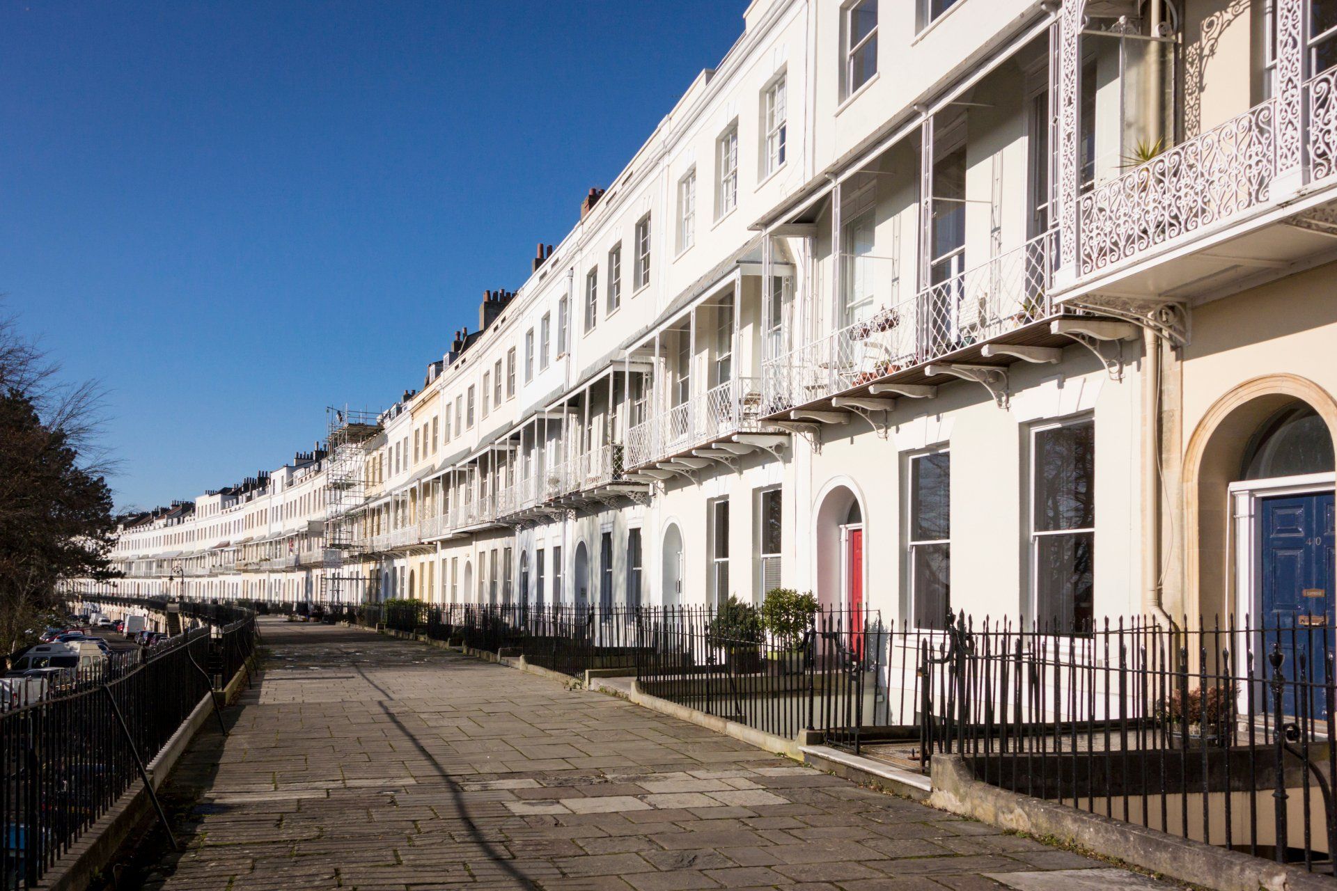 A row of white houses with balconies on a sunny day.
