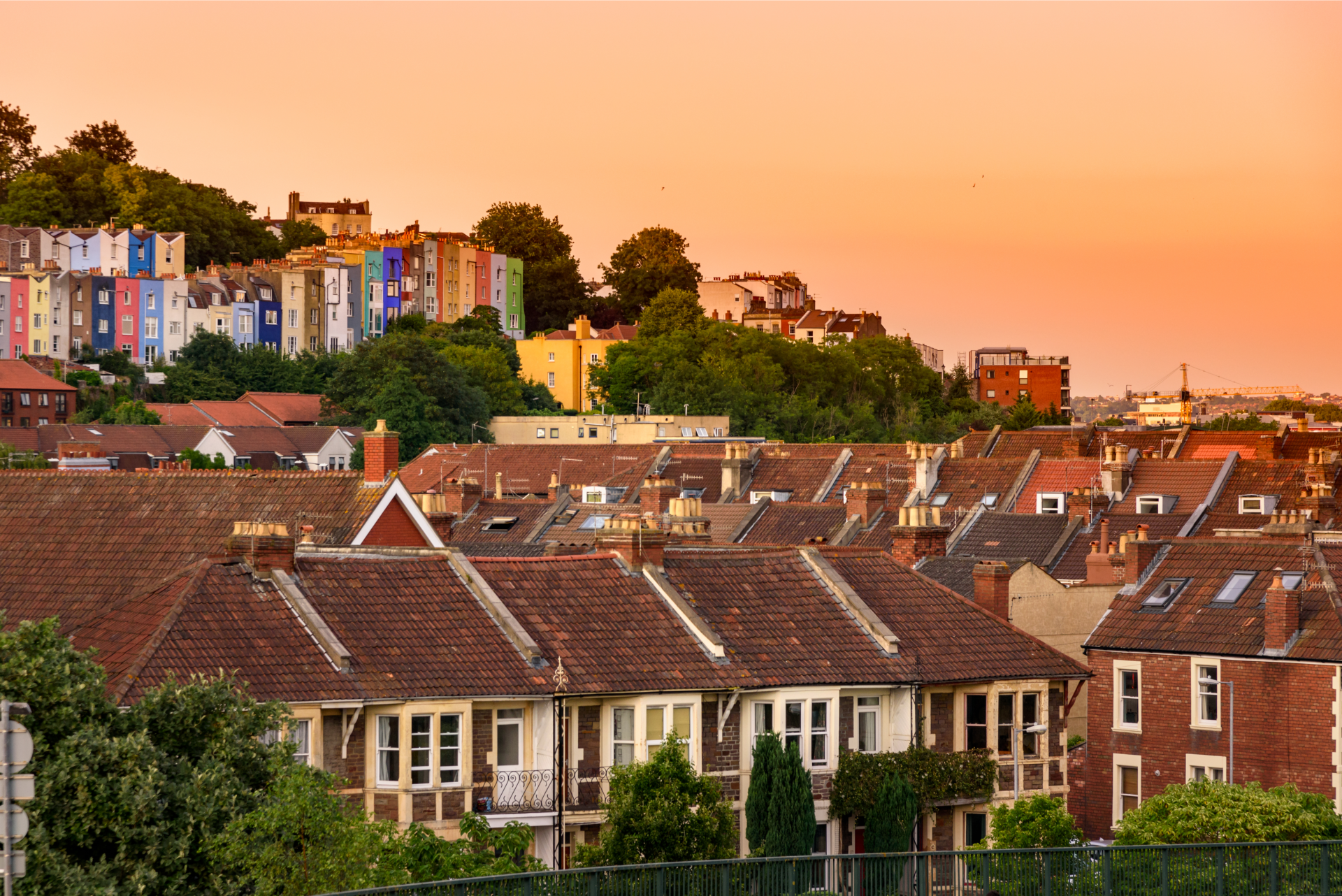 A row of houses with a sunset in the background