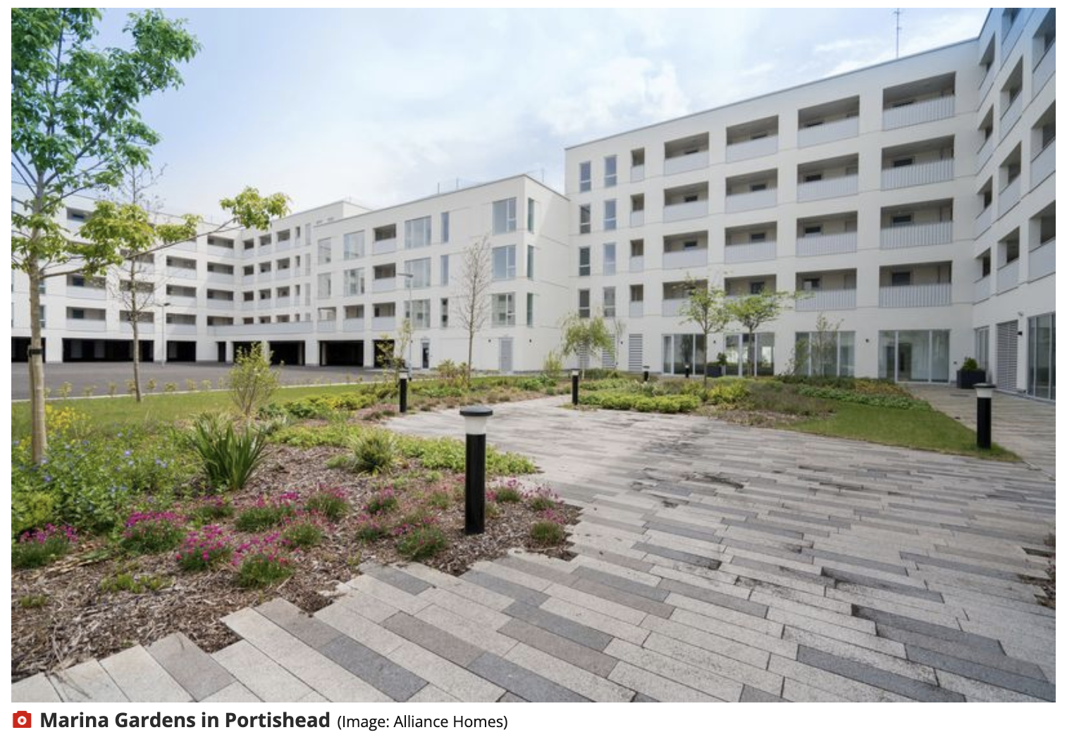 A large white building with a courtyard in front of it.