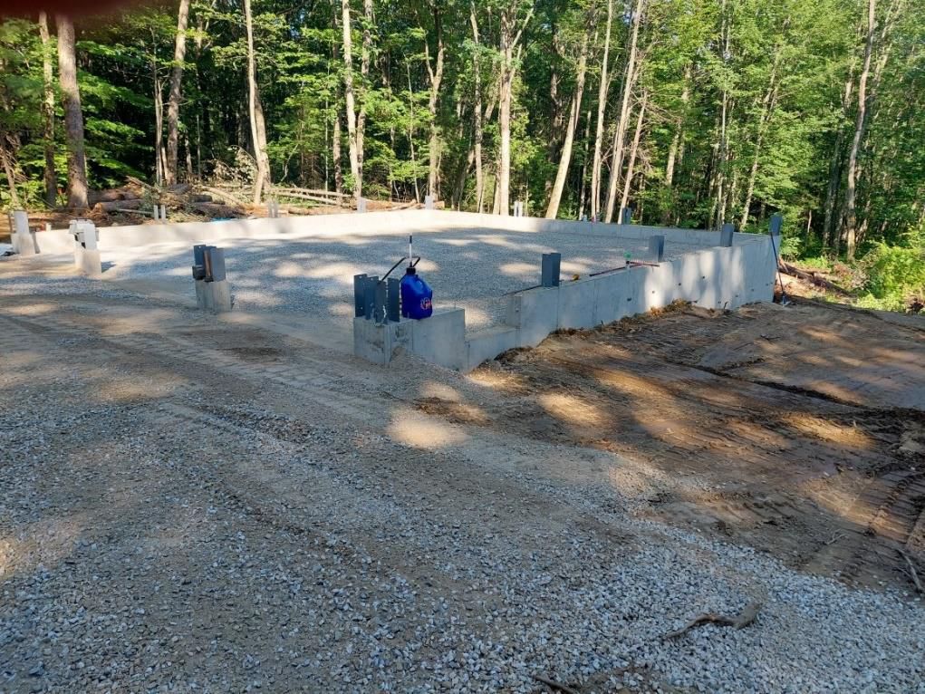 A concrete foundation is being built in the middle of a forest.