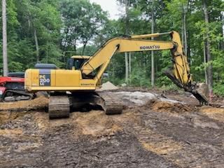 A yellow excavator is digging a hole in the dirt.