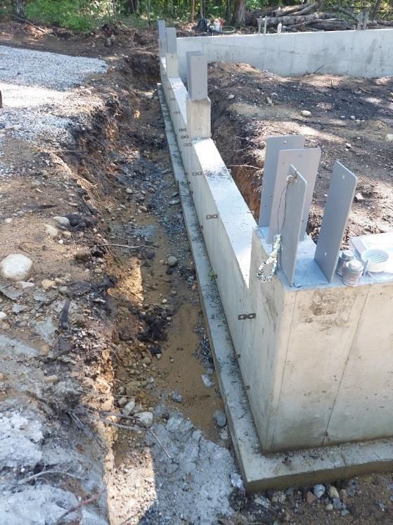 A concrete wall is being built in a dirt field.