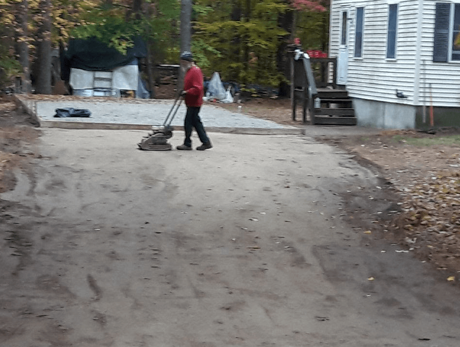 Worker Grading the Driveway Area