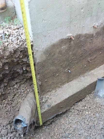 Worker Measuring Excavated Area for New Foundation