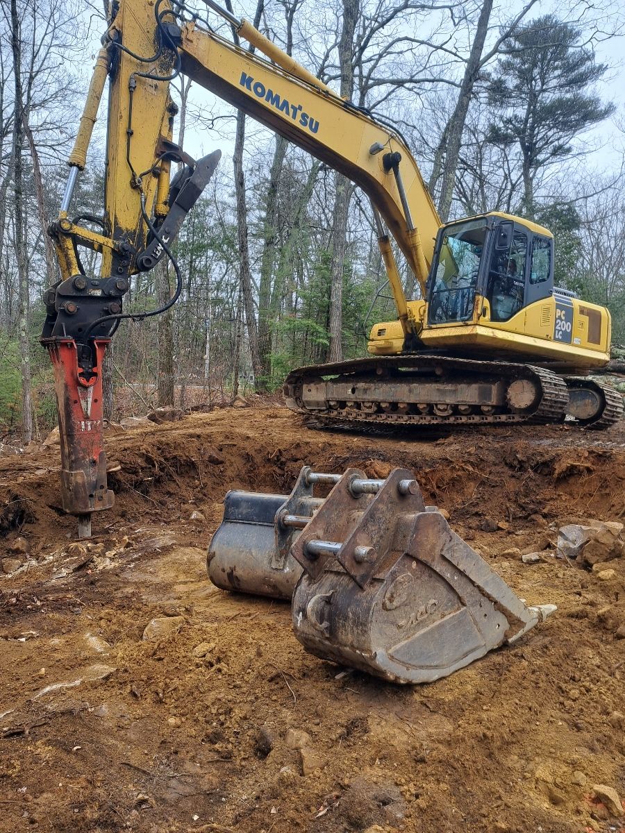 A large yellow excavator is digging a hole in the dirt.