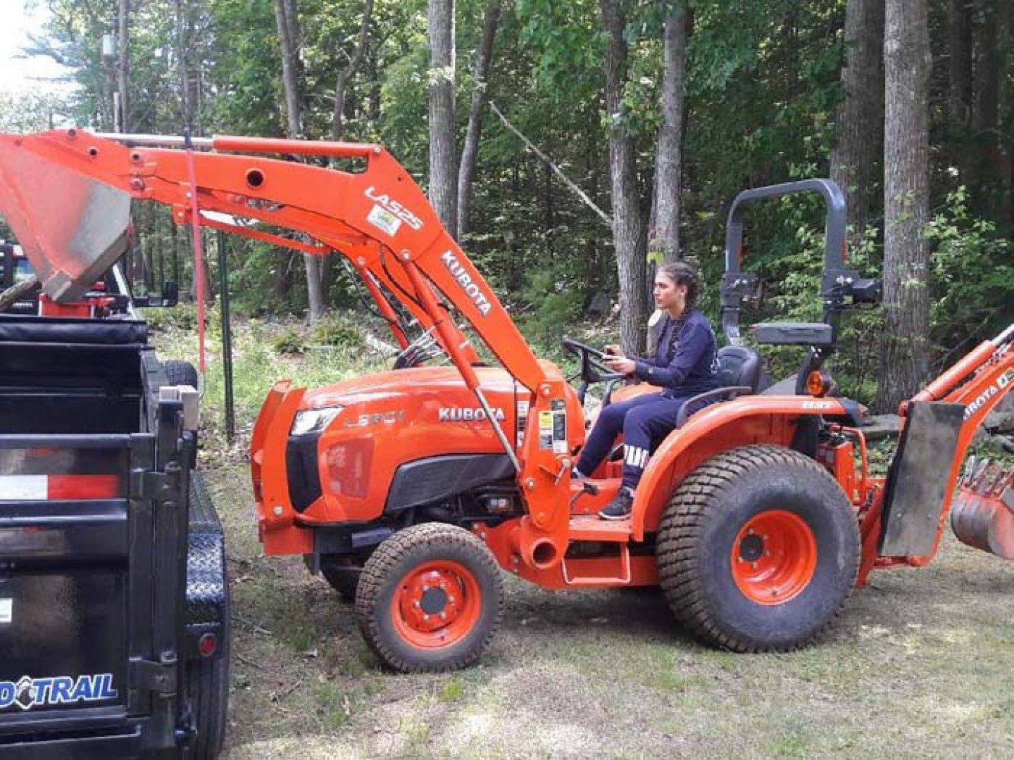 Woman Loading a Pick Up Truck Using a Front Loader