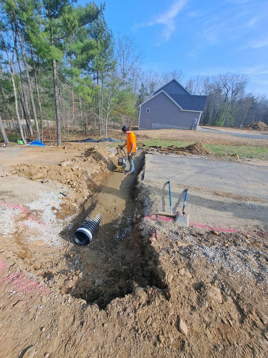 A man is digging a hole in the dirt in front of a house.