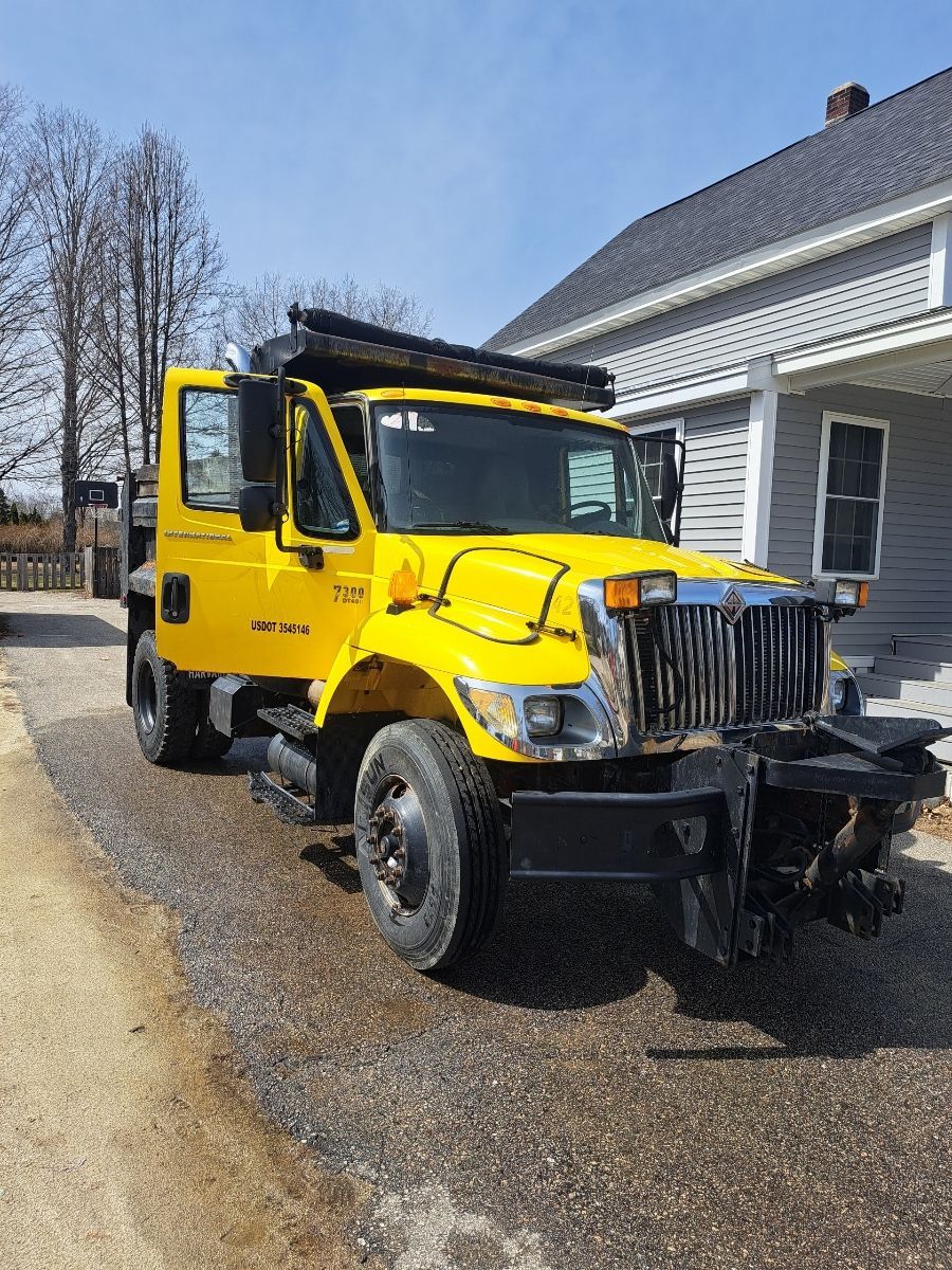 A yellow truck is parked in front of a house.