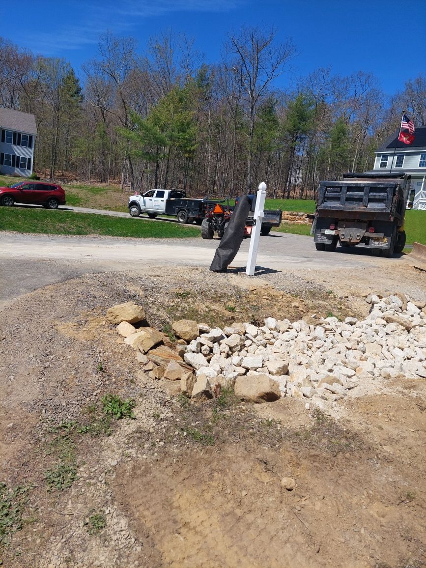 A dump truck is parked on the side of the road next to a mailbox.