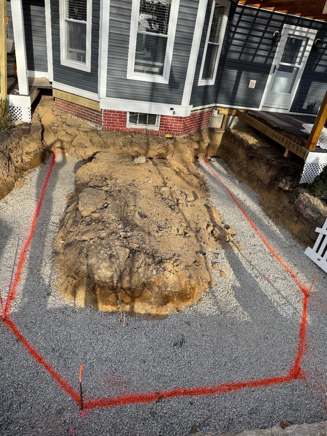 A large pile of dirt is sitting in front of a house.