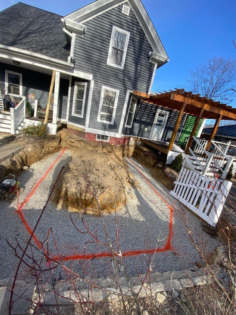 A large hole in the ground in front of a house.