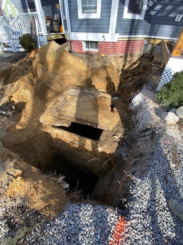 A large hole in the ground in front of a house.