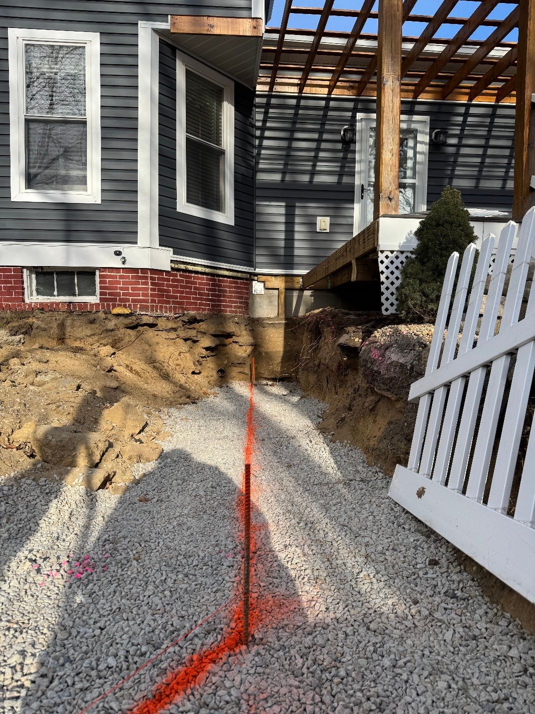 A white picket fence is sitting in front of a house.