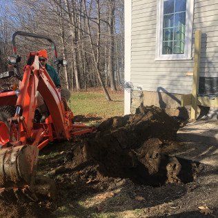Worker Operating a Small Backhoe