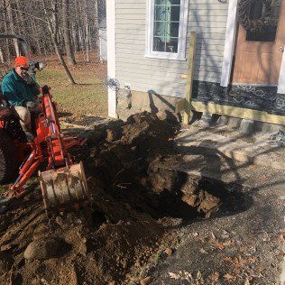 Worker Operating a Small Backhoe for Excavation