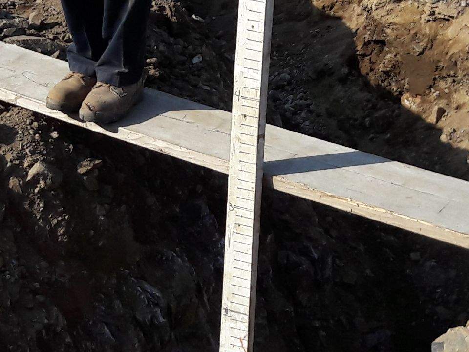 Worker Measuring the Excavation Depth