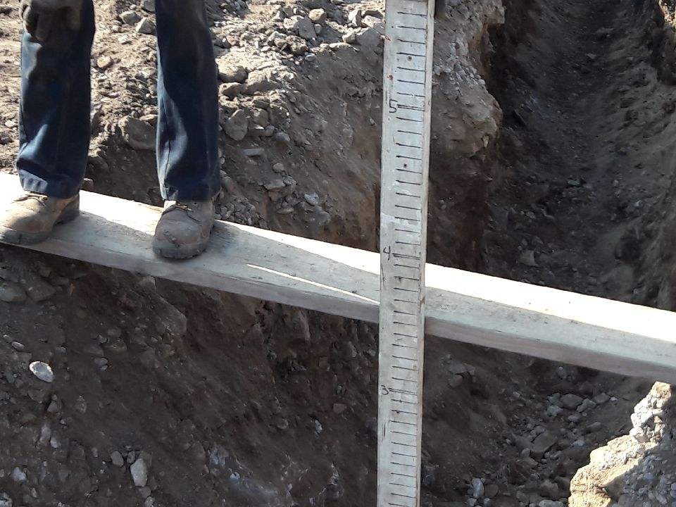 Another Worker Measuring the Excavation Depth