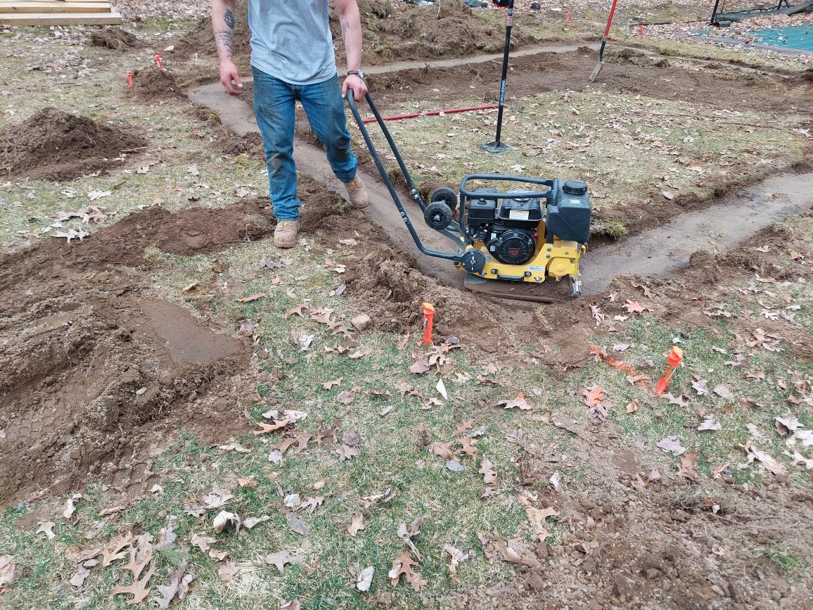 Professional Worker Grading an Area Using a Compactor