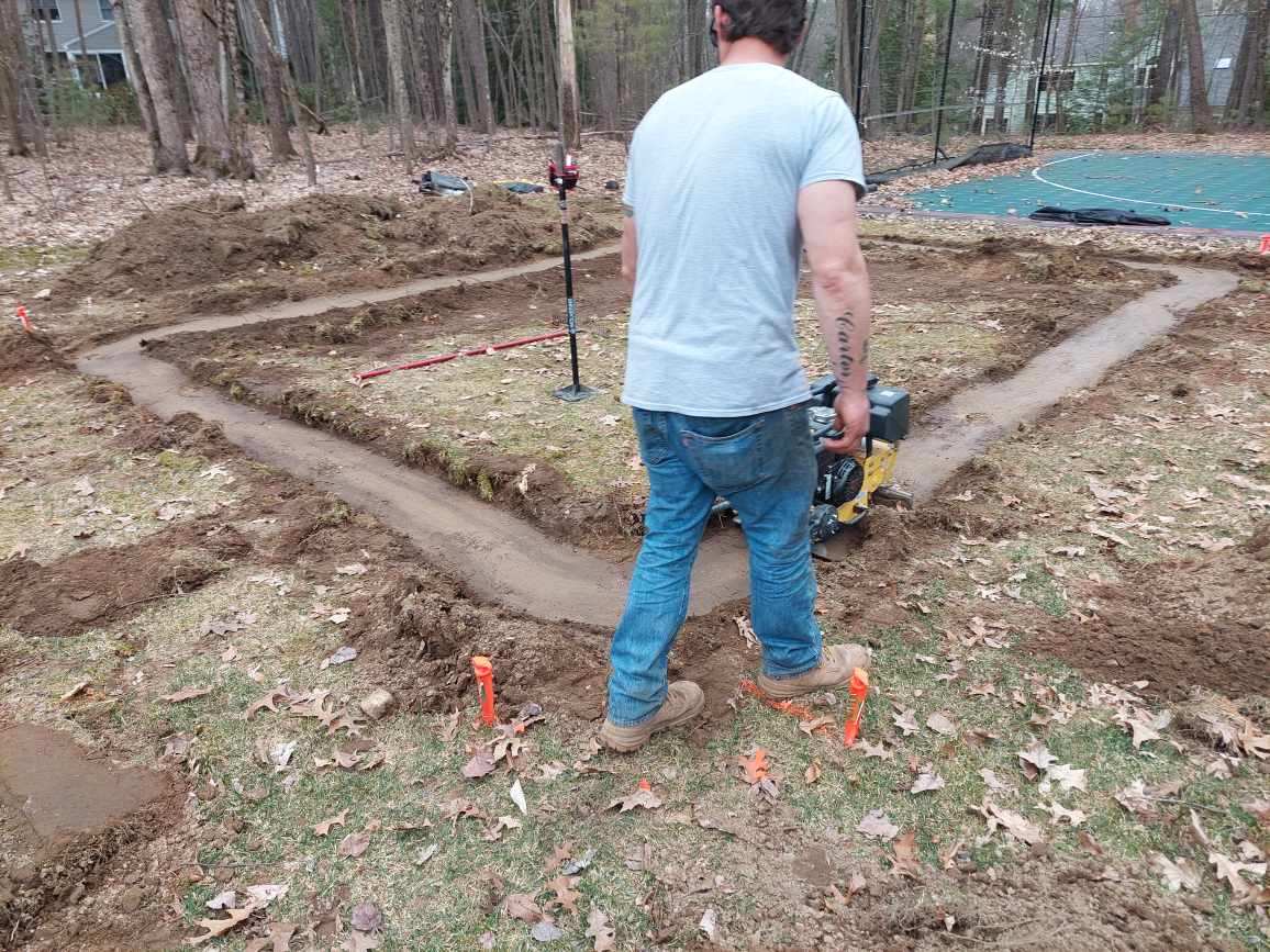Worker Grading Some Part of an Open Area Using a Compactor