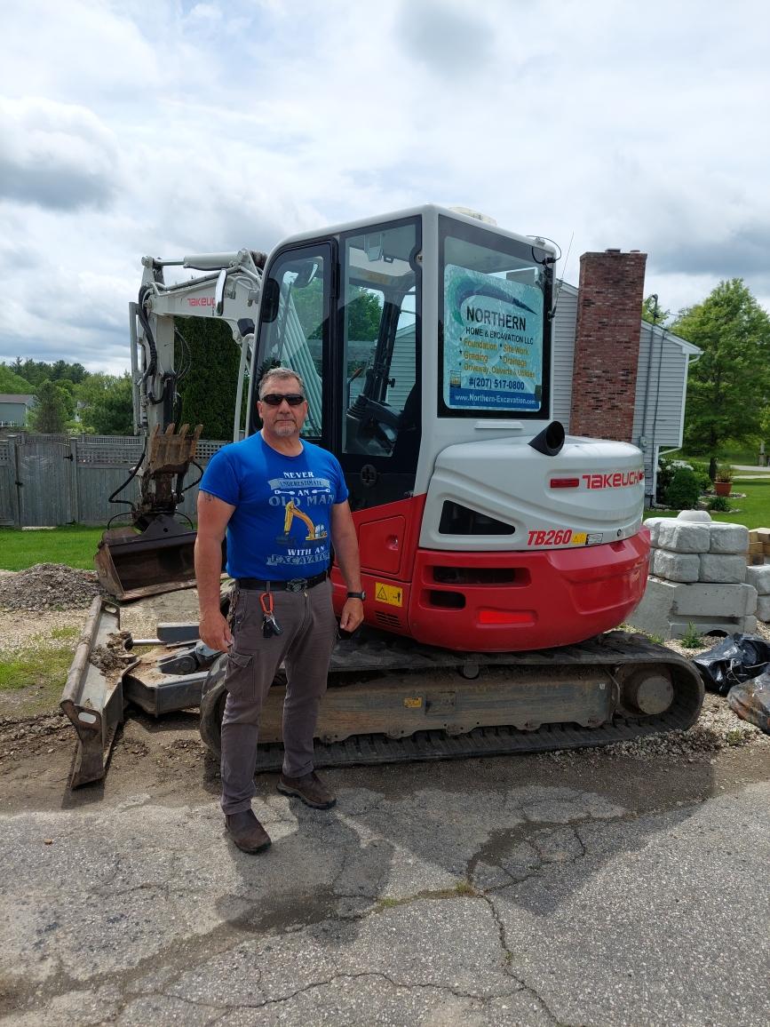 Owner Standing in Front of Excavator